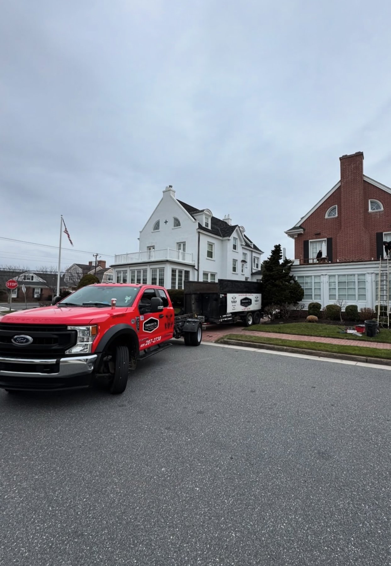 Fantazzia's Co. truck and trailer in front of shore properties